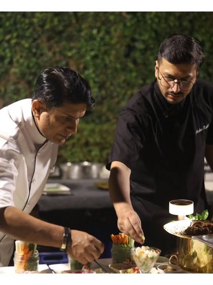 Two of our chefs collaborate on plating a dish, demonstrating the teamwork and precision that defines our kitchen. This behind the scenes look builds confidence in our professional process.