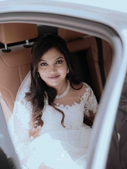 A close-up of the bride in the car, her veil framing her face beautifully.
