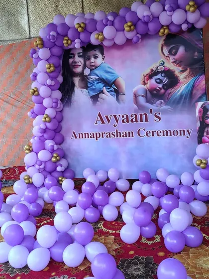 I also provide decorations for traditional Indian ceremonies. This is a setup for an Annaprashan (first rice-eating ceremony) with a personalized backdrop, framed by a purple and white balloon arch.