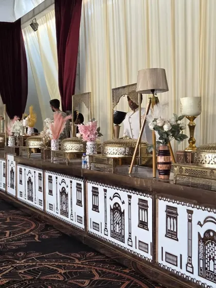 A closer look at our detailed buffet counter design for a wedding. The custom facade with traditional 'jharokha' patterns, combined with modern table lamps and floral decor, showcases our ability to blend classic and contemporary styles.