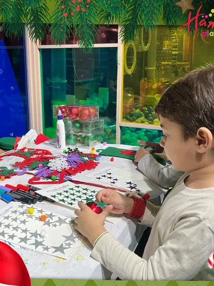 A child carefully adds stickers and stars to his Christmas stocking craft. I provide all the materials so their creativity can run wild.