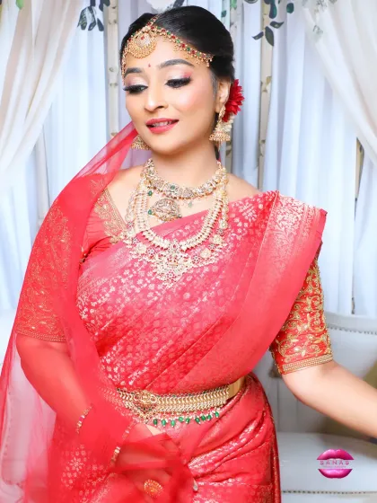 This pose captures the elegance of the South Indian bride. The soft makeup, combined with the rich red saree and gold jewellery, creates a look of pure grace.