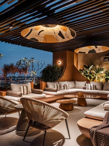 The custom pendant lights, with their unique artistic patterns, become a primary feature at night. They cast a soft, patterned light that enhances the tropical modernism of the space.