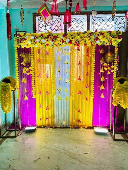A closer look at the details of an indoor Haldi backdrop. I use multiple layers of fabric, hanging floral elements, and LED lights to add depth and brightness to the decoration, making it perfect for photos.
