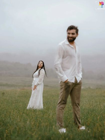 A candid portrait with a focus on the groom-to-be, with his partner in the soft-focused background, creating a sense of depth and story.