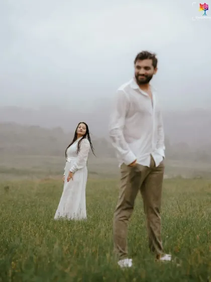 A candid portrait with a focus on the groom-to-be, with his partner in the soft-focused background, creating a sense of depth and story.