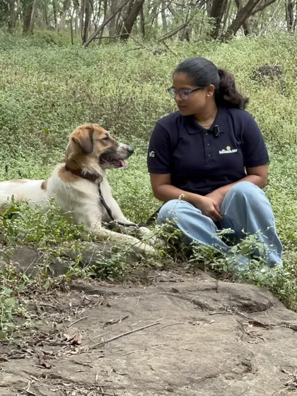 Taking a quiet break during a nature walk, sitting side-by-side with a happy dog. These moments of shared calm are just as important as the active parts of our sessions, reinforcing our bond in a peaceful setting.