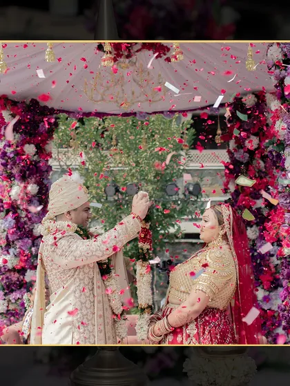 A close-up of the Varmala exchange, with guests showering the couple with petals. It's these joyful, candid moments that make a wedding special.