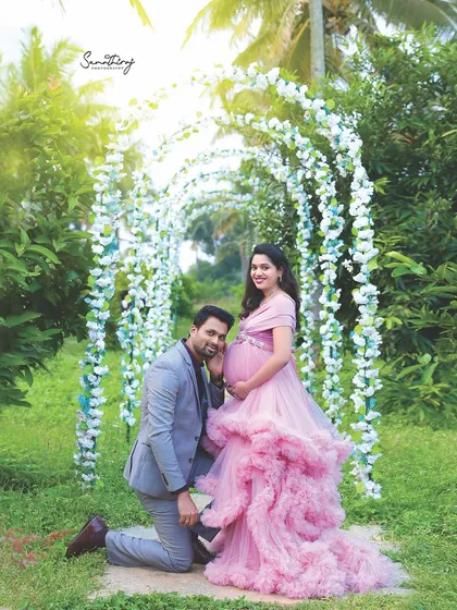 Another angle of a romantic moment under the floral arch. The father-to-be listens to the baby bump, sharing a special connection with his unborn child in our beautiful garden.