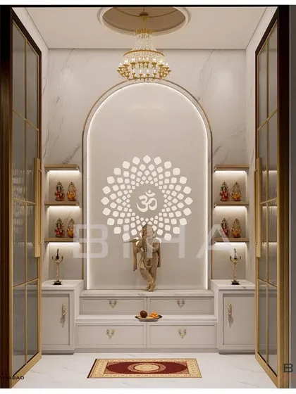 This pooja room design demonstrates our ability to create modern sacred spaces. We used white marble for its purity, framing an arched niche with soft, integrated lighting. The backlit 'Om' mandala creates a serene focal point, while glass doors with brass frames provide a sense of enclosure without sacrificing visual connection to the home.