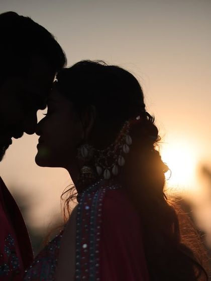 A stunning silhouette of a couple against the setting sun. This is the epitome of a romantic, cinematic shot, where the focus is purely on their connection and the beautiful moment.