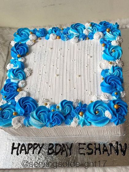 A beautiful square sheet cake with a border of blue and white buttercream roses. Sheet cakes are a great option for serving larger crowds.