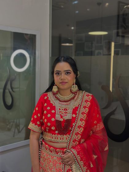 From the engagement glow to full bridal glam, our students learn to craft looks for every wedding event. This stunning red lehenga look is a testament to their skill.