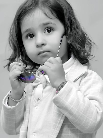 A striking black and white close-up portrait of a little girl, highlighting her beautiful eyes and thoughtful expression.