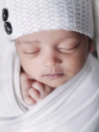 A macro shot focusing on the serene face of a sleeping newborn. These close-ups are perfect for appreciating their tiny, perfect features.