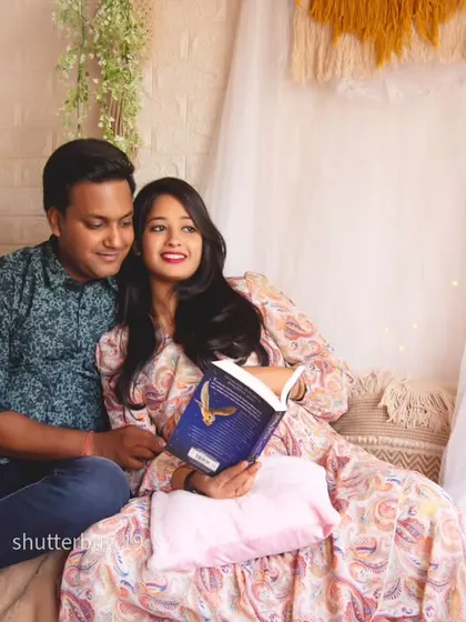 A sweet moment of the couple reading a book together in our cozy studio corner. This pose is perfect for capturing a shared, quiet activity you enjoy as a couple before the baby arrives.