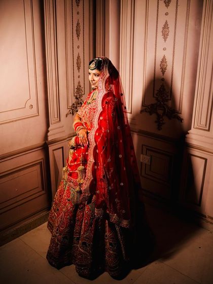 A classic bridal portrait. The deep red veil and the soft lighting make her look so regal and timeless.