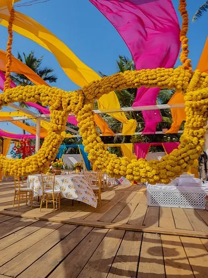 A fun, oversized pair of sunglasses made of marigolds, hanging from a colourful canopy. It's all in the details!