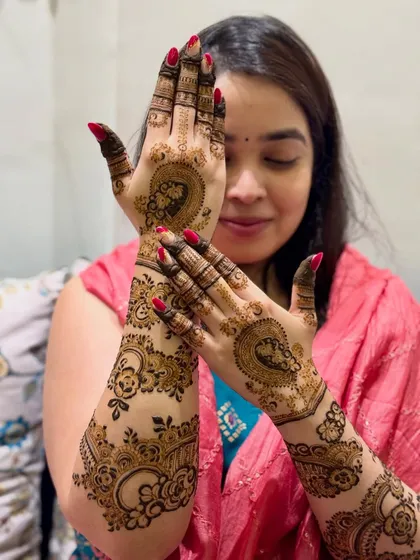 This lovely bride is showcasing her full-arm mehendi, which features portraits and floral patterns.