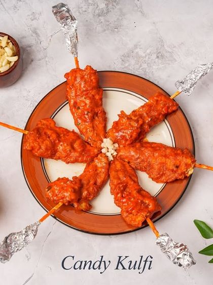 A unique take on a classic, our Candy Kulfi is actually a savoury chicken starter. Chicken is shaped like a kulfi, fried, and served on a stick, making it a fun and tasty appetizer.