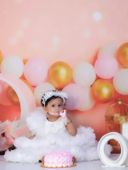 A messy and joyful cake smash session. This little girl is covered in frosting and having the best time celebrating her first birthday.