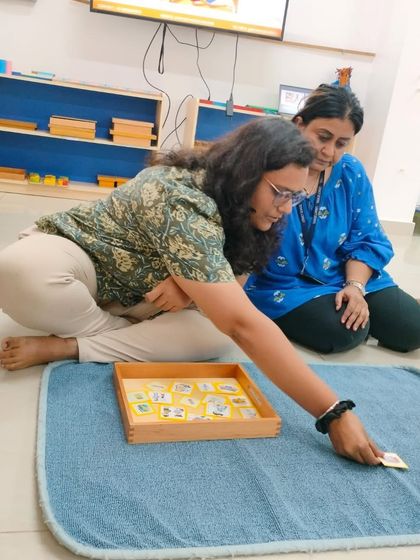 A teacher at Legacy School explores a set of nomenclature cards, a key material for vocabulary building and classification in a Montessori classroom.