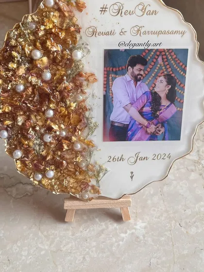 Another view of the frame featuring intricate varmala designs and a beautiful couple's photo. The pearls scattered among the flowers add a touch of classic elegance.