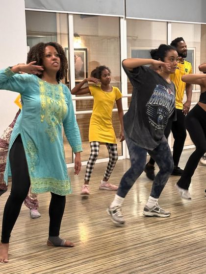 A close-up of workshop participants learning the intricate hand movements of a Bollywood routine.