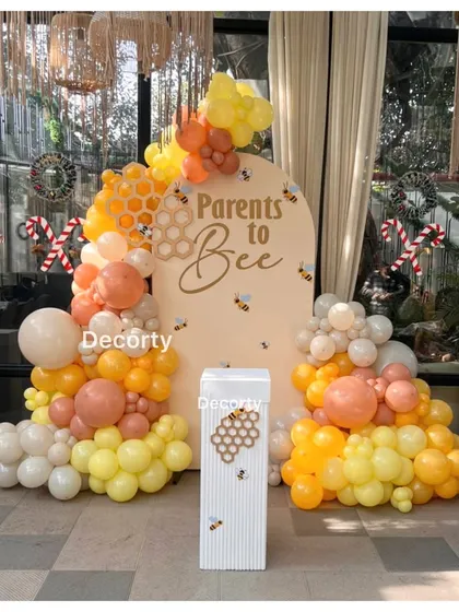 The 'Parents to Bee' backdrop, complete with honeycomb details, bee accents, and candy cane props.