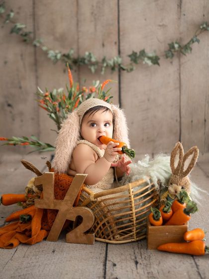 This little bunny can't resist a little nibble on a carrot during his half-birthday shoot.