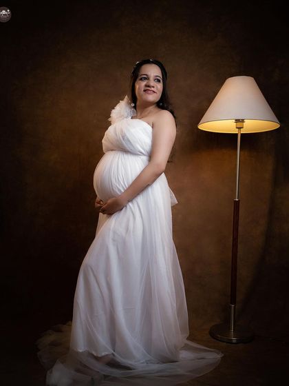 Incorporating simple props like this floor lamp can add a touch of warmth and intimacy to a studio portrait, making the scene feel more personal and styled.