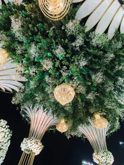 I also design elaborate ceiling decorations. Here, I mixed lush greenery with hanging crystal chandeliers and large white floral structures to cover the entire ceiling of the venue.