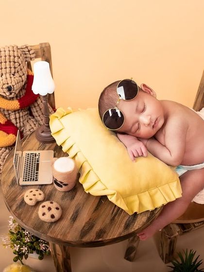 Even the tiniest clients need a coffee break. This humorous and creative newborn setup features a miniature desk, laptop, and coffee, perfect for parents who love a bit of fun.