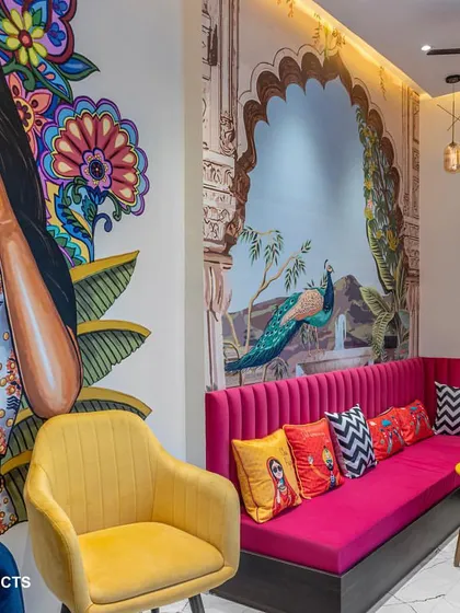 A close-up of the vibrant lounge, featuring a custom pink sofa, colorful cushions, and a bold, modern mural that brings energy and personality to the space.
