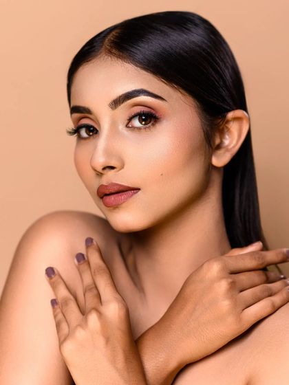 Another example of a flawless beauty headshot. This image showcases the precision of the makeup application, from the defined brows to the clean lipstick line, ideal for an MUA's portfolio.