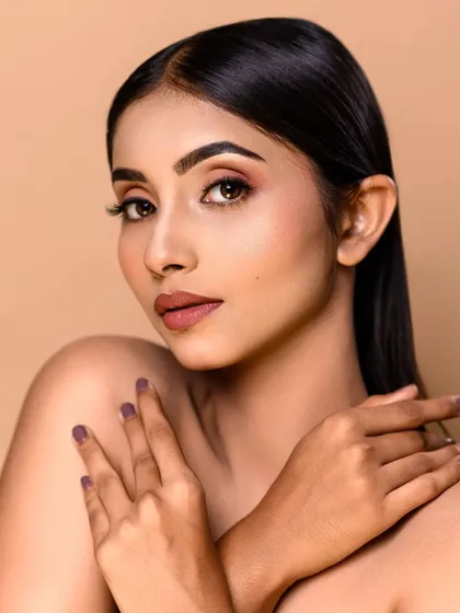 Another example of a flawless beauty headshot. This image showcases the precision of the makeup application, from the defined brows to the clean lipstick line, ideal for an MUA's portfolio.