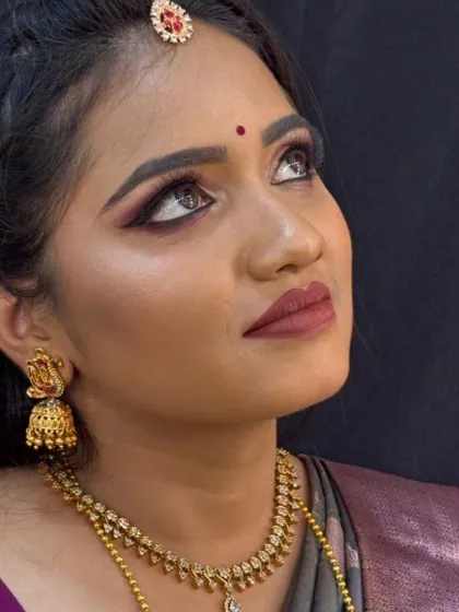 An upward glance showcases the detailed eye makeup and the traditional jhumka earrings, part of a complete reception look.