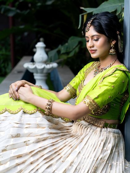 Wrapped in elegance, this half saree features a light gold tissue lehenga paired with a vibrant lime green princess katori blouse. The entire ensemble, including the dupatta, is finished with intricate handwork for a look of traditional grace.