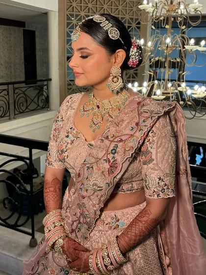 The side profile highlights the elegant hair bun and the soft contouring of her makeup.