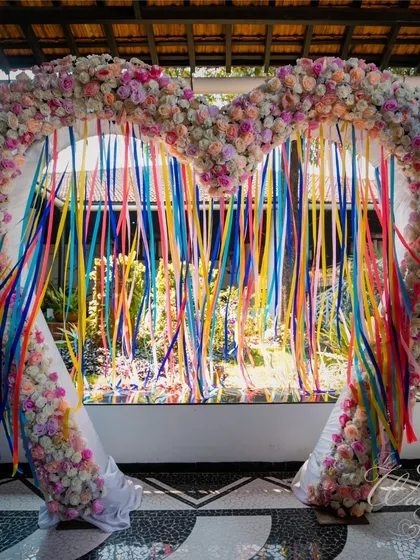 A heart-shaped floral arch with colorful ribbons makes for a perfect photo booth and entrance. It's a whimsical and romantic element that adds a touch of fun to any Mehendi ceremony.