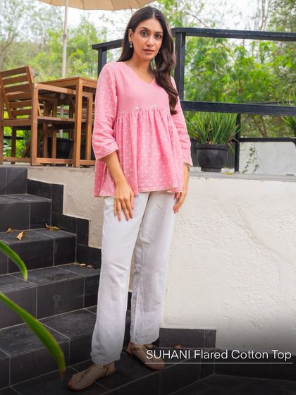 The Suhani Flared Cotton Top in pink Bandhani is a perfect blend of comfort and style. Paired here with simple white pants, it creates a breezy, feminine look suitable for a casual day out.