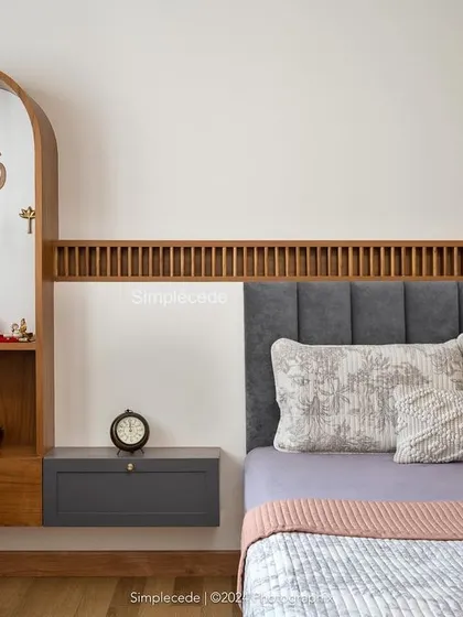 In this guest bedroom, we integrated a custom arched puja unit beside the bed. The design continues the fluted paneling detail from the headboard, creating a cohesive and sacred space.