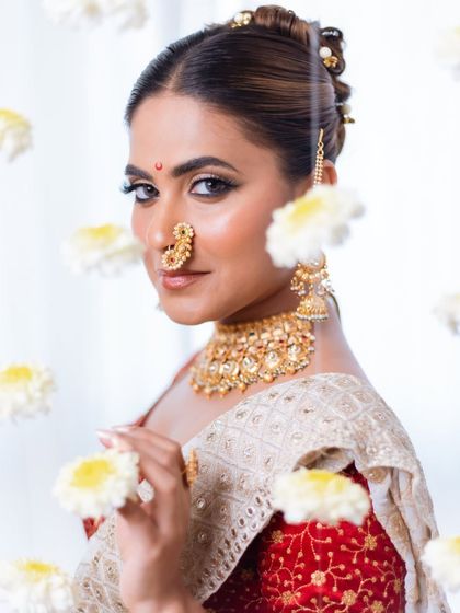 A creative and dreamy portrait. The floating flowers add a touch of magic to this modern take on a traditional Marathi bride, highlighting her glowing skin and defined eyes.