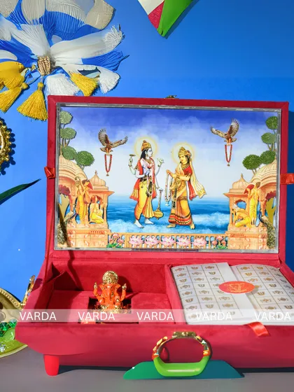 This Ram and Sita themed wedding gift box is a work of devotional art. The plush red velvet case opens to reveal a three-dimensional temple art scene, a space for your invitation, and a small Ganesha idol, blending spirituality with luxury.