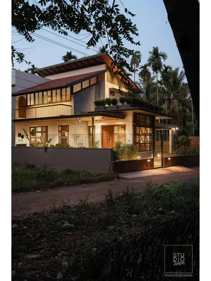 The exterior of the 'Olive Dwelling' at twilight, showing how the design merges traditional sloping roofs with modern forms and materials.