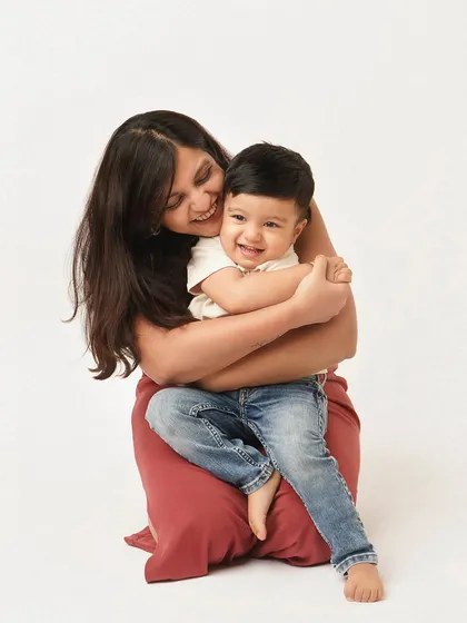 A mother embraces her son, both of them beaming with happiness. This is a portrait of pure, uncomplicated love.