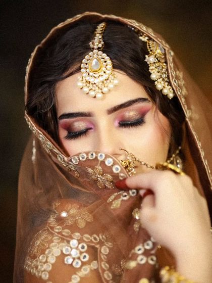 A coy pose with the dupatta, focusing on the stunning eye makeup with a hint of pink.