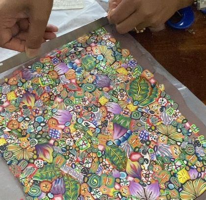 The process of making my polymer clay trinket dishes. Here, I'm cutting the slab of clay, which is a mosaic of hundreds of tiny, handmade patterns.