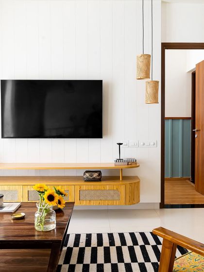 This TV unit features a light wood finish with cane-fronted cabinets, bringing a touch of modern farmhouse charm to the living room.