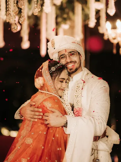 A heartfelt hug between the bride and groom, showered with petals. This image is all about the raw emotion and comfort they find in each other amidst the wedding rituals.